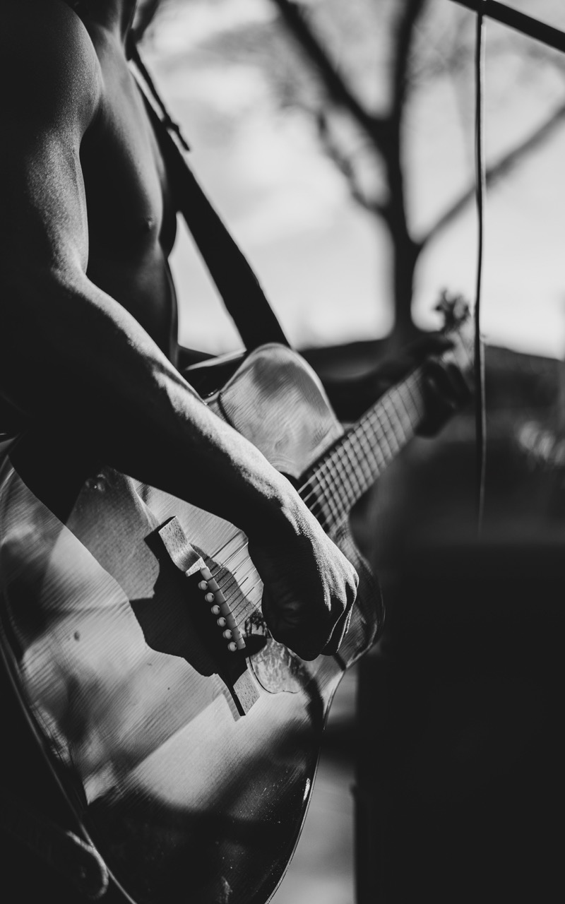 Maurice's hands on an acoustic guitar, outdoor light